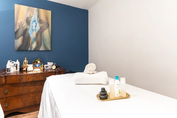 Treatment room with a deep blue wall and a wooden chest
