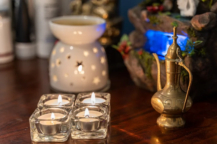 Tea lights in glass holders beside an oil burner