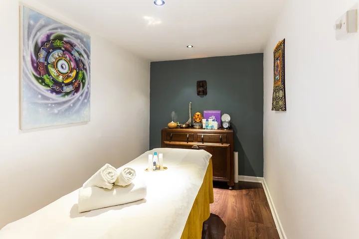 Treatment room with a mandala painting and a dark green wall